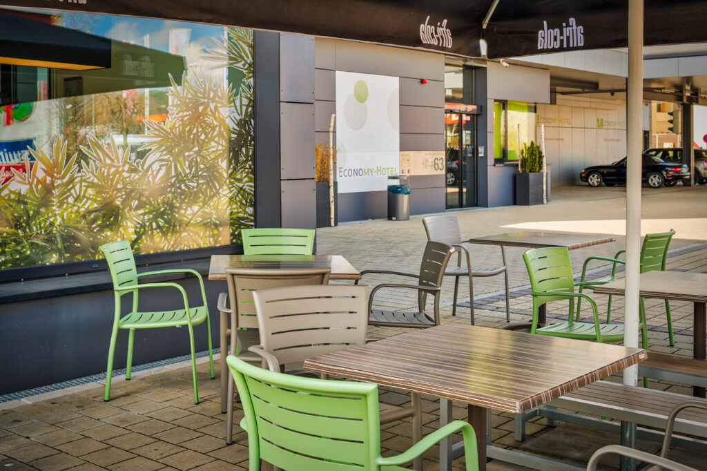 Im Außenbereich vor dem Hotel finden Sie begrenzte Parkmöglichkeiten mit Überdachung, einen Mülleimer mit Aschenbecher für die Raucher und mit Abstand dazu einige Sitzgelegenheiten und Sonnenschirme, um schönes Wetter genießen zu können.